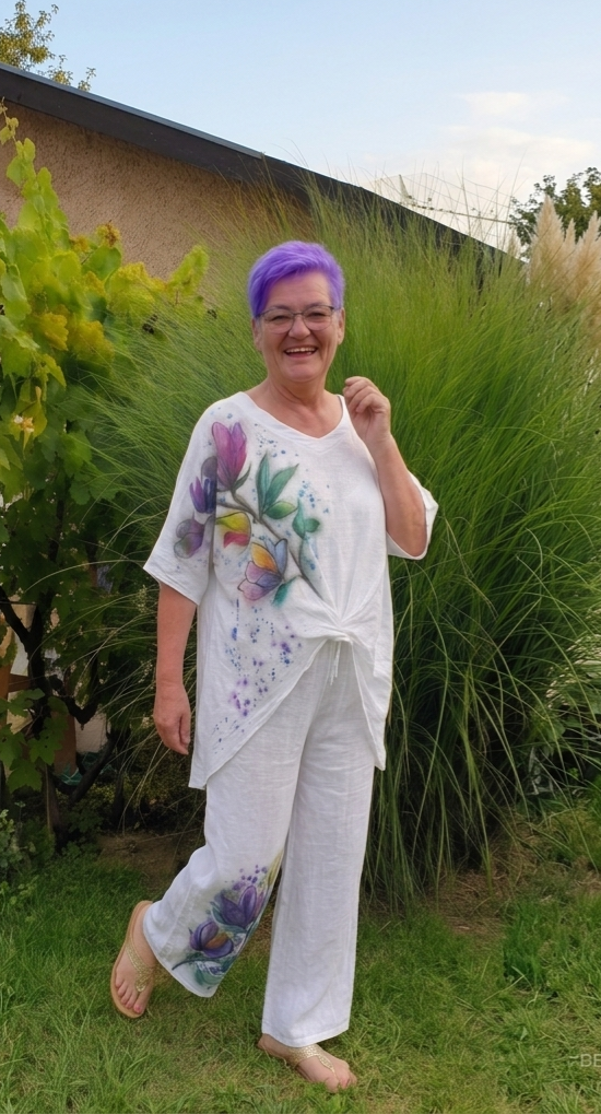 Žena u bijelom lanenom kompletu 100% lan s ručno oslikanim ljubičastim magnolijama na tunici i hlačama - Irena Colorena